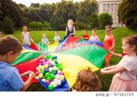 Close view colorful parachute with balls. Kids in circle 67161724