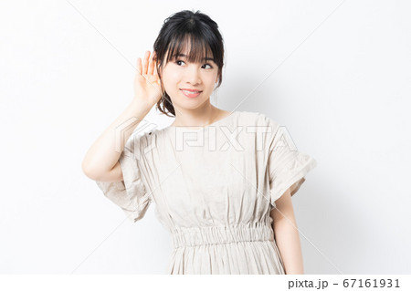 聞き耳をたてる若い女性 聞き耳をたてる若い女性 67161931