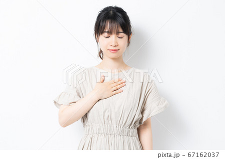 胸に手を当てる若い女性 67162037