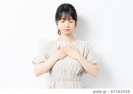 胸に手を当てる若い女性 67162039