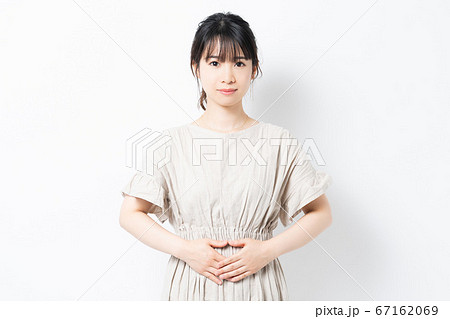 お腹に手を当てる若い女性 お腹に手を当てる若い女性 67162069