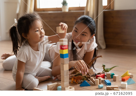 Little biracial baby girl playing cubes with mommy. 67162095