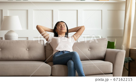 Calm relaxed young asian ethnic woman sleeping on cozy couch. 67162215