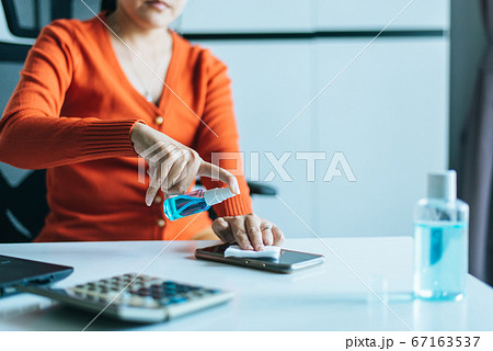Hands woman cleaning dirty mobile phone on screen,Preventive measures against coronavirus,Covid-19,Work at home,Working from home Hands woman cleaning dirty mobile phone on screen,Preventive measures against coronavirus,Covid-19,Work at home,Working from home 67163537