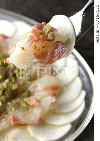 透明な平皿に盛り付けてある鯛とカブのカルパッチョを食べる 67166151