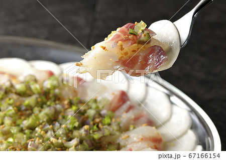 透明な平皿に盛り付けてある鯛とカブのカルパッチョを食べる 67166154