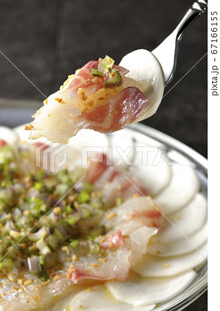 透明な平皿に盛り付けてある鯛とカブのカルパッチョを食べる 67166155