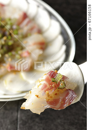 透明な平皿に盛り付けてある鯛とカブのカルパッチョを食べる 67166158