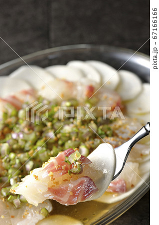 透明な平皿に盛り付けてある鯛とカブのカルパッチョを食べる 67166166