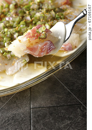 透明な平皿に盛り付けてある鯛とカブのカルパッチョを食べる 67166167
