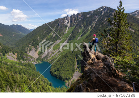 Girl on Top of Cliff with Beautiful View of Canadian Mountain Landscape 67167239
