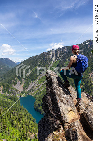 Girl on Top of Cliff with Beautiful View of Canadian Mountain Landscape 67167242