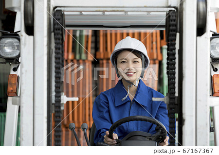 フォークリフトを操作する女性作業員 フォークリフトを操作する女性作業員 67167367