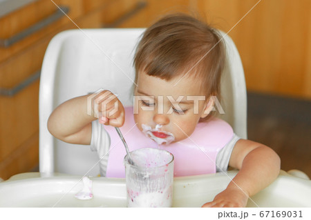 portrait of a child who eats baby food with his spoon. my face is smeared with food portrait of a child who eats baby food with his spoon. my face is smeared with food 67169031
