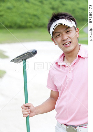 バンカーレーキを持つ男性 67169478