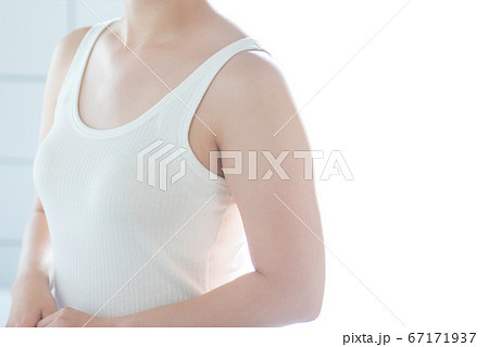 白いタンクトップの女性のスキンケアイメージの写真素材
