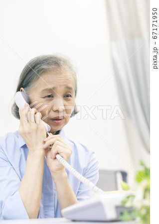 固定電話で通話するシニア女性 67171950