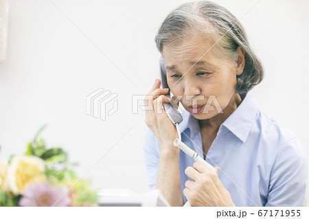 固定電話で通話するシニア女性 67171955