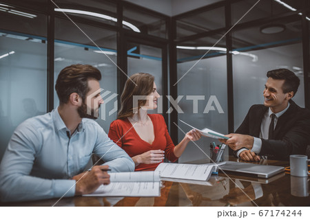 Sales agent giving a contract to a couple 67174244