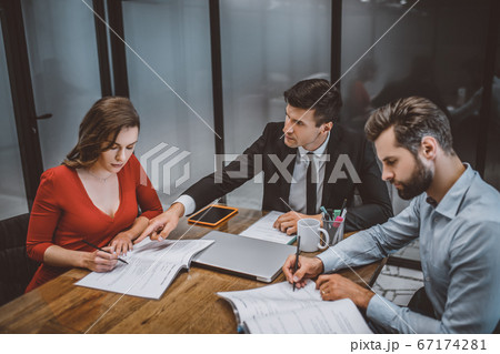 Lawyer helping a couple to fill legal papers Lawyer helping a couple to fill legal papers 67174281