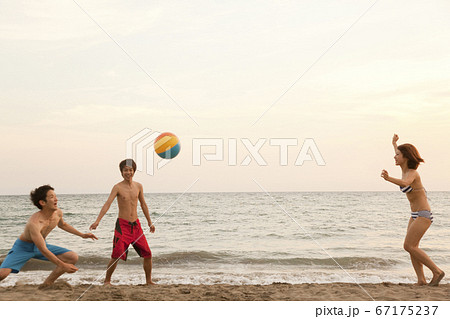 ビーチボールで遊ぶ男女の写真素材