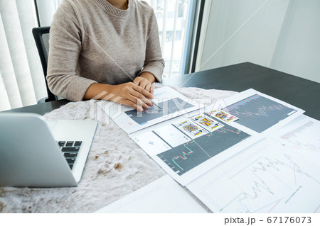 Young women sitting with laptop, stock chart and cards, Don't play stockshare like gambling concept Young women sitting with laptop, stock chart and cards, Don't play stockshare like gambling concept 67176073
