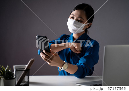 Asian woman in blue shirt wearing protective face 67177566