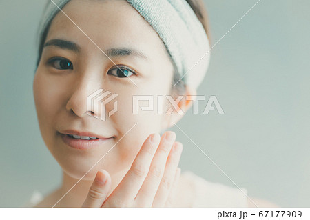 フェイスケアをするヘアバンドをした30代女性 67177909