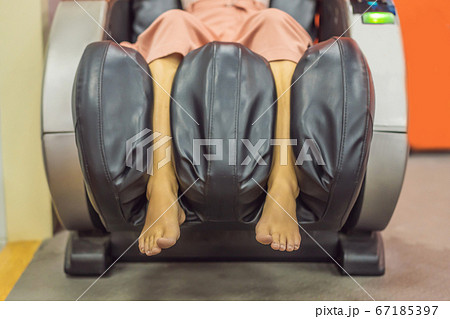 Beautiful young woman relaxing on the massage chair in airport or in the mall 67185397