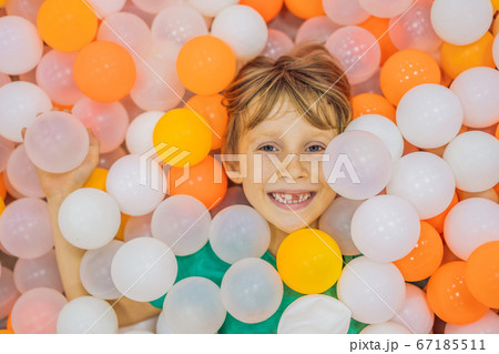 Child playing in ball pit. Colorful toys for kids. Kindergarten or preschool play room. Toddler kid at day care indoor playground. Balls pool for children. Birthday party for active preschooler Child playing in ball pit. Colorful toys for kids. Kindergarten or preschool play room. Toddler kid at day care indoor playground. Balls pool for children. Birthday party for active preschooler 67185511