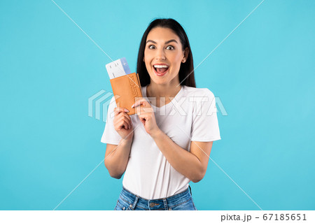 Excited caucasian woman holding tickets and passport Excited caucasian woman holding tickets and passport 67185651