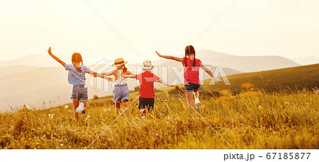 Anonymous happy children running backin field. 67185877