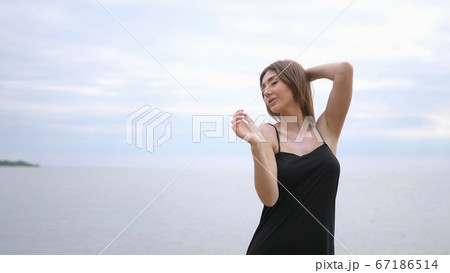 Young beautiful woman dancing on the seashore 67186514
