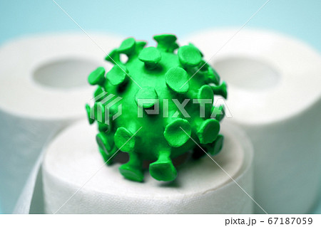 Green model of coronavirus on the toilet paper roll 67187059