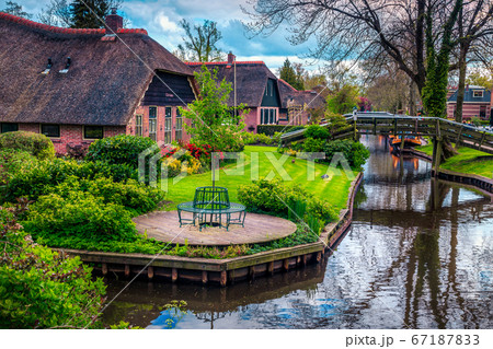 Dutch village with colorful ornamental garden and water canal, Giethoorn Dutch village with colorful ornamental garden and water canal, Giethoorn 67187833