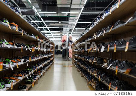 large shoe store with long shelves filled with shoes 67188165