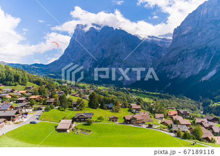 青い空と雲とアルプス山脈と家々 67189116