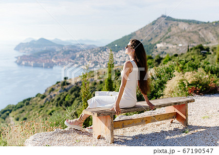 beautiful girl in summer dress relax with sea view and mountains 67190547