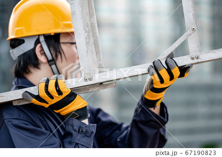 Maintenance worker man carrying aluminium ladder 67190823