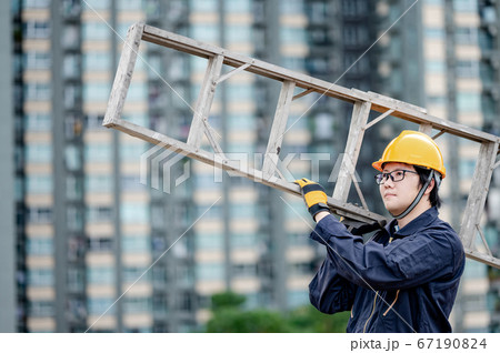 Maintenance worker man carrying aluminium ladder Maintenance worker man carrying aluminium ladder 67190824