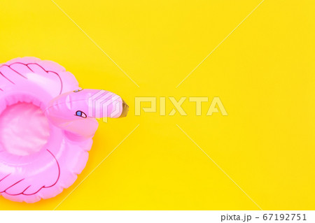 Summer beach composition. Simply minimal design with pink Inflatable flamingo isolated on yellow background. Pool float party, trendy celebrity fashion concept. Flat lay top view copy space. 67192751