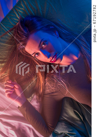 Portrait of a young woman on a bed from above 67192782