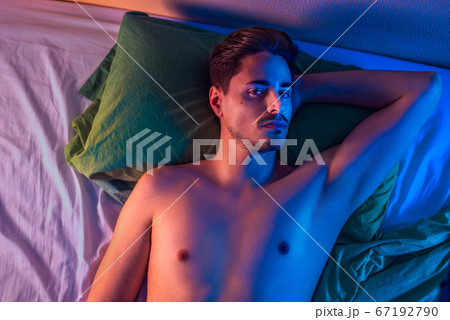 Portrait of a young man on a bed from above 67192790