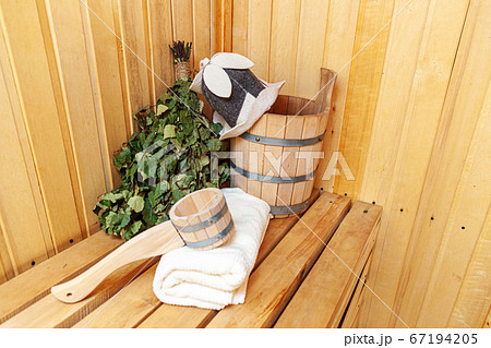 Interior details Finnish sauna steam room with traditional sauna accessories basin birch broom scoop felt hat towel. Traditional old Russian bathhouse SPA Concept. Relax country village bath concept. 67194205