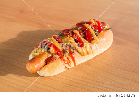 Delicious New York style Hot Dog with sausage, mustard, chili, ketchup, onion and bits of bacon. Delicious New York style Hot Dog with sausage, mustard, chili, ketchup, onion and bits of bacon. 67194278