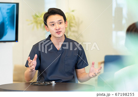 診察する若い医師と患者 67198255