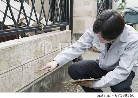 老朽化した住宅の塀を調査するビジネスマン 老朽化した住宅の塀を調査するビジネスマン 67199560