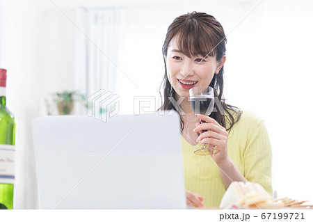 ノートパソコンでオンライン飲み会をする若い女性 67199721