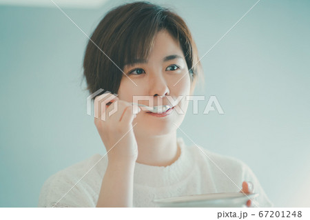 スプーンで食べるアラサー女性 67201248