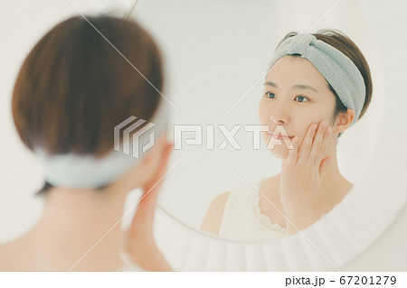 ヘアバンドをしてスキンケアをする30代女性 ヘアバンドをしてスキンケアをする30代女性 67201279
